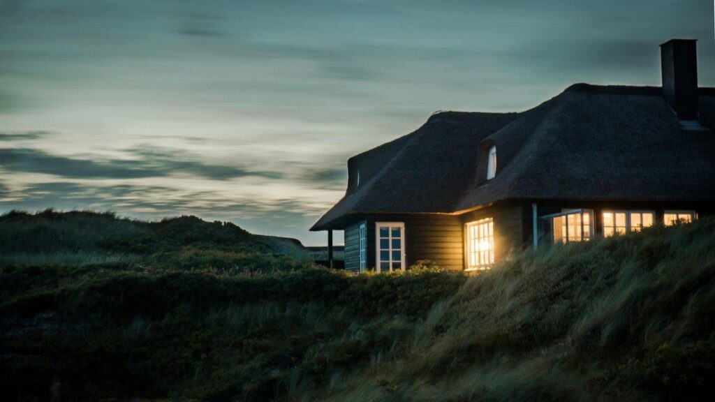 Gray house in field at twilight - top design trends to incorporate in your green home this year