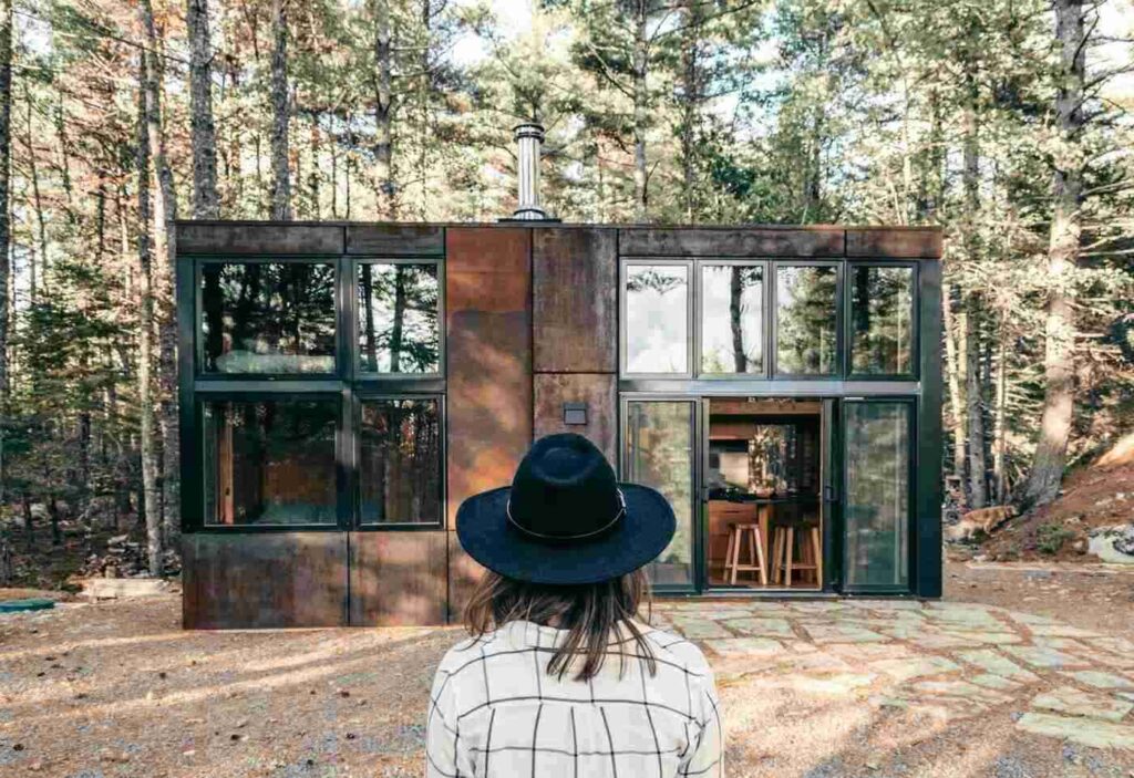 Woman standing in front of modern cottage - modular homes in canada