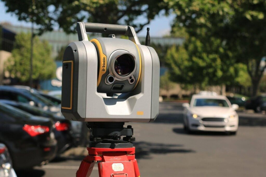 Theodolite in parking lot - 4 things to know about surveying and how it works