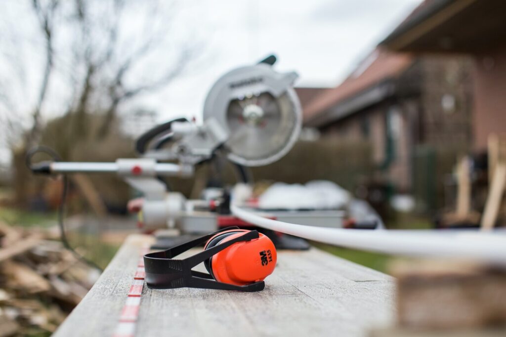 Ear protectors next to mitre saw on job site - a guide to getting the most out of your construction project