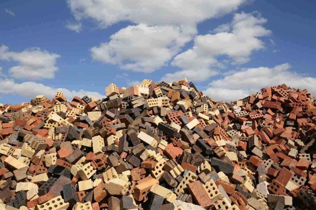 Pile of bricks under blue sky with clouds - green building guide to reducing waste