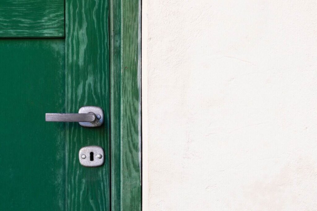 Close up of green door and handle - how to properly air seal your home