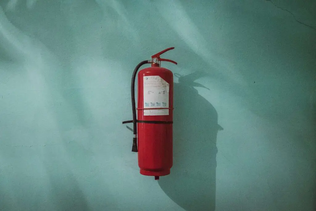 Fire extinguisher against green wall - how eco-friendly is fire safety equipment
