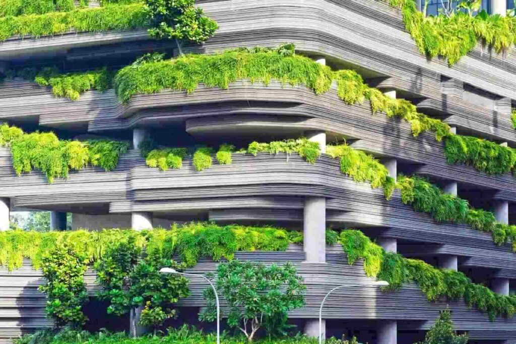 Green building with lots of foliage on balconies